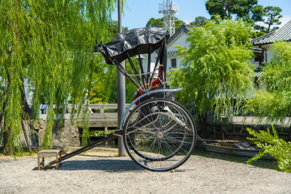 柳と白壁の町並みを背景にした美観地区の人力車